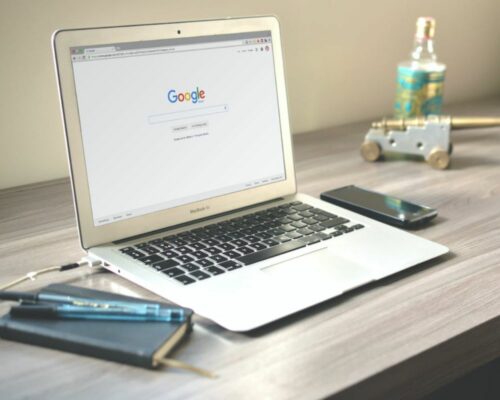 What is the best way to create a website? A laptop is sitting on a desk.